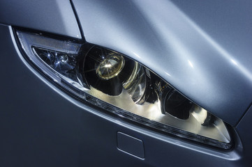 Headlight and hood of powerful sports car with stars on lamps, sedan bodywork with silver blue...