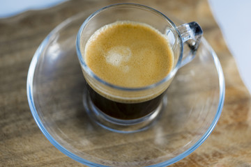 Frothy Black Coffee in Glass Mug on Table