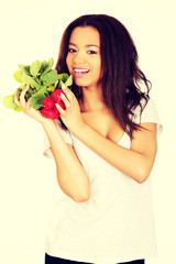 Young woman with bunch of radishes.