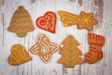 Fresh baked decorated gingerbread on old wooden background, christmas time