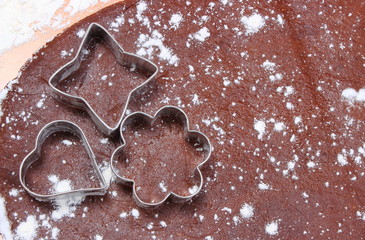 Cookie cutters lying on dough for cookies
