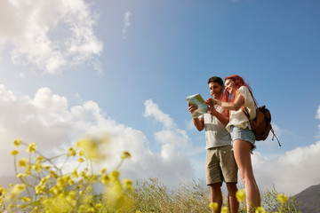 Young couple reading map on country walk