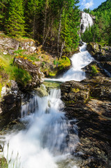 Fototapeta na wymiar High waterfall in the summer woods