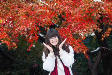 Young Chinese woman in action with autumn leaves
