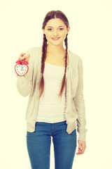 Happy teenage woman with alarmclock.