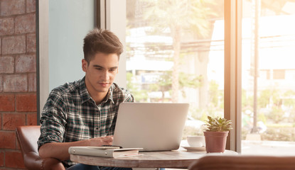 Businessman using laptop with tablet and pen on wooden table in