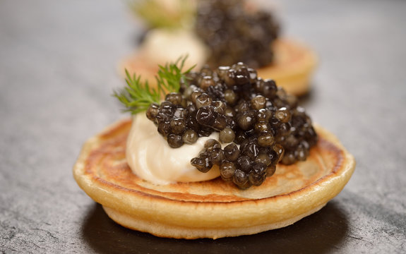 Mini pancakes with black caviar
