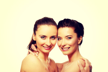 Two sisters with make up embracing.