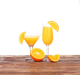 Glass of freshly pressed orange juice with sliced orange half on wooden table