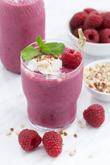 Fresh raspberry smoothie with nuts, vertical, closeup