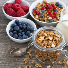 glass jar with granola, milk, and fresh berries 