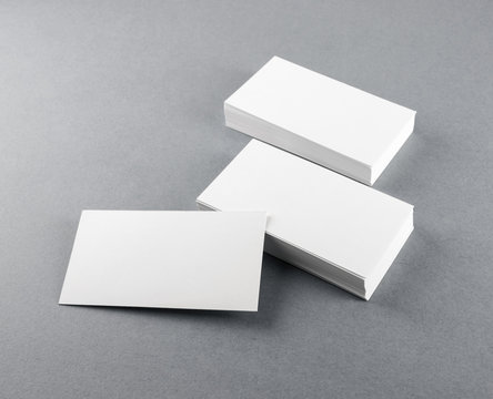 Photo of blank business cards with soft shadows on gray background. Template for branding identity.