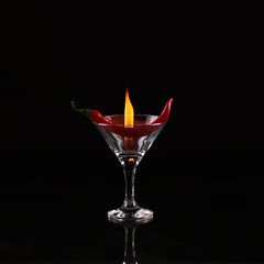 Burning alcoholic drinks with ice cubes, on black background