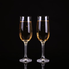 A glass of champagne, on a black background.