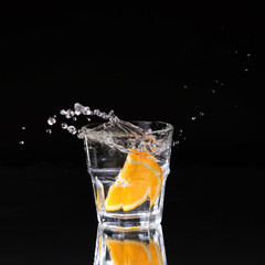 martini cocktail splashing into glass on black background