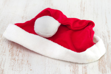 Obraz na płótnie Canvas Santa Claus red hat on white wooden background