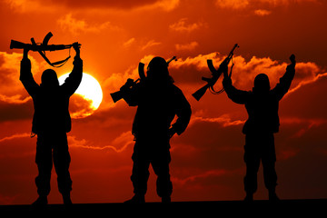 Silhouette of military soldier or officer with weapons at sunset. shot, holding gun, colorful sky,...