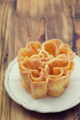 typical portuguese dessert filhos on white plate on brown wooden background