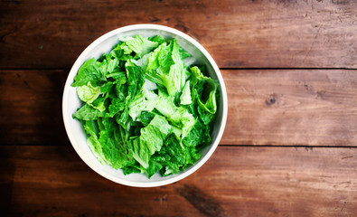 ..Fresh Green salad in a white bowl on rustic background with co