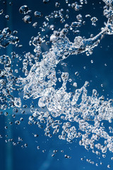 Waterdrops levitating in the air on blue