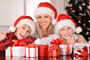Fototapeta na wymiar Mom and children in santa hats