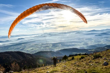 Fotobehang Luchtsport Paraglider begint van een berg