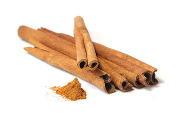 Cinnamon sticks and powder on white background.