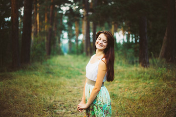 A smiling red hair caucasian girl in a dress is breathing fresh 