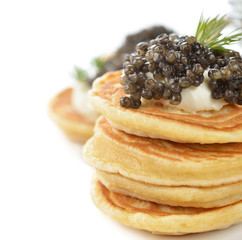 Mini pancakes with black caviar