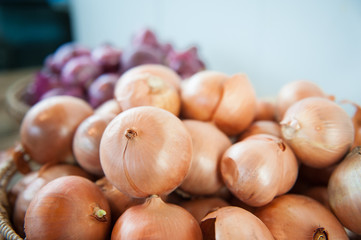 Golden onion heap on market shelf