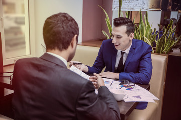 two businessmen communicate happily negotiating in the cafe