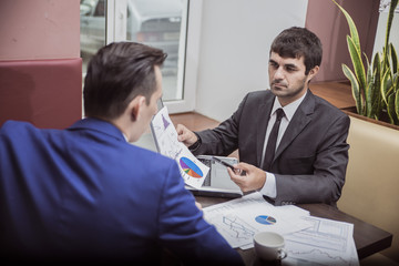 two businessmen communicate happily negotiating in the cafe