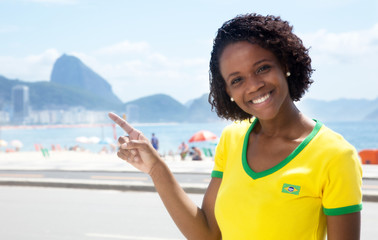 Brasilianerin in Rio de Janeiro zeigt zum Zuckerhut