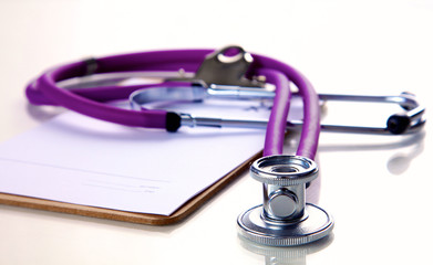 A medical stethoscope near a laptop on a wooden table, on white