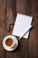 Notebook and coffee with copy space on a wooden background. selective focus.
