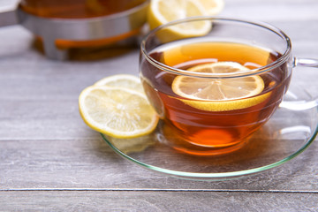 reshly brewed tea in glass cup wooden background