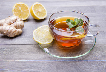 reshly brewed tea in glass cup wooden background