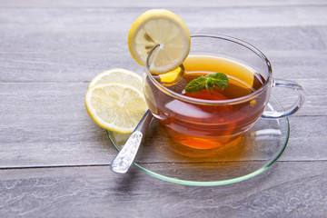 reshly brewed tea in glass cup wooden background