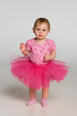 Little girl stand against the gray background