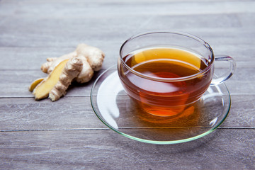 reshly brewed tea in glass cup wooden background