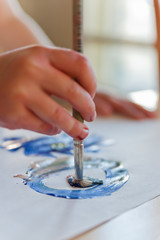 Obraz premium Close up of child`s hand holding brush and painting.