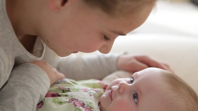 young girl playing with a little baby