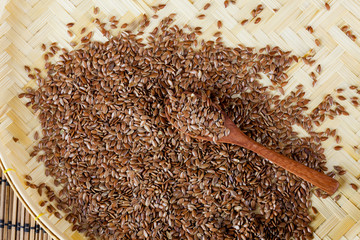 flax seed with spoon placed on flat woven basket
