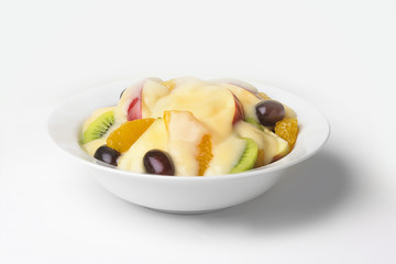 A bowl of sliced mixed fruit with fresh cream custard.
