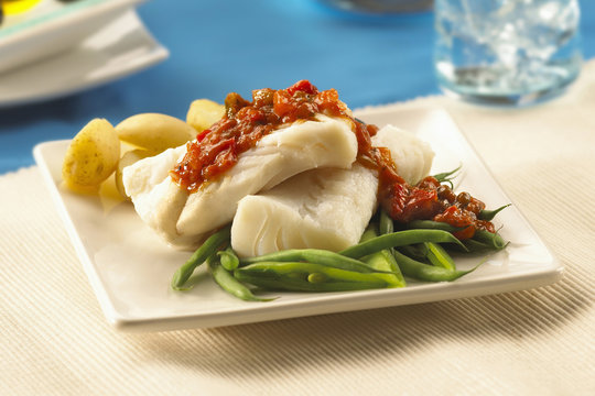 Plate Of Freshly Steamed Cod Fish With Ratatouille Dressing, Served With New Potatoes And Green Beans.