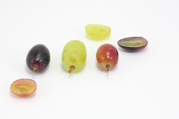 Red green and black grapes on white background