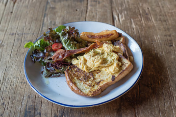french toast breakfast served with omelette sausage and bacon