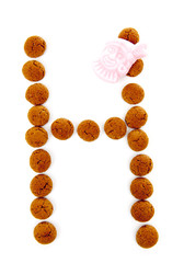 Ginger nuts, pepernoten, in the shape of letter H isolated on wh