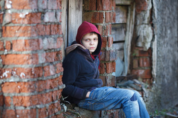 dramatic portrait of a little homeless boy