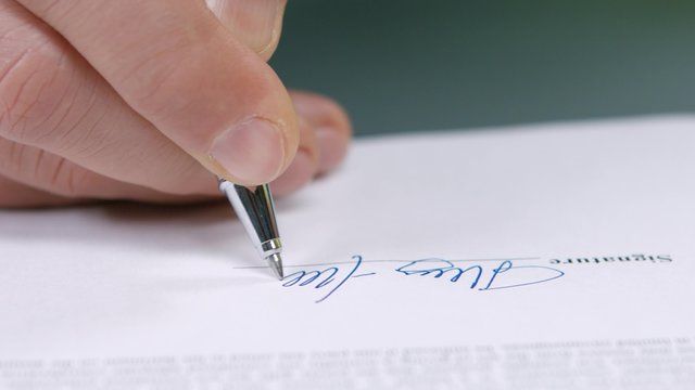 Businessman signs a document.